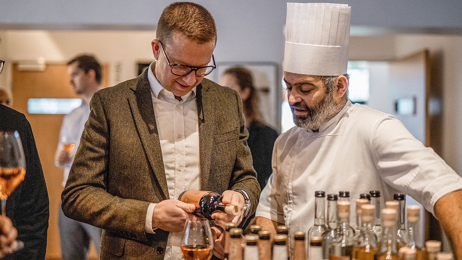 Rasmus Pape, indkøbschef i Lidl, står med Michelin-kokken Wassim Hallal og ser på et produkt i en flaske.