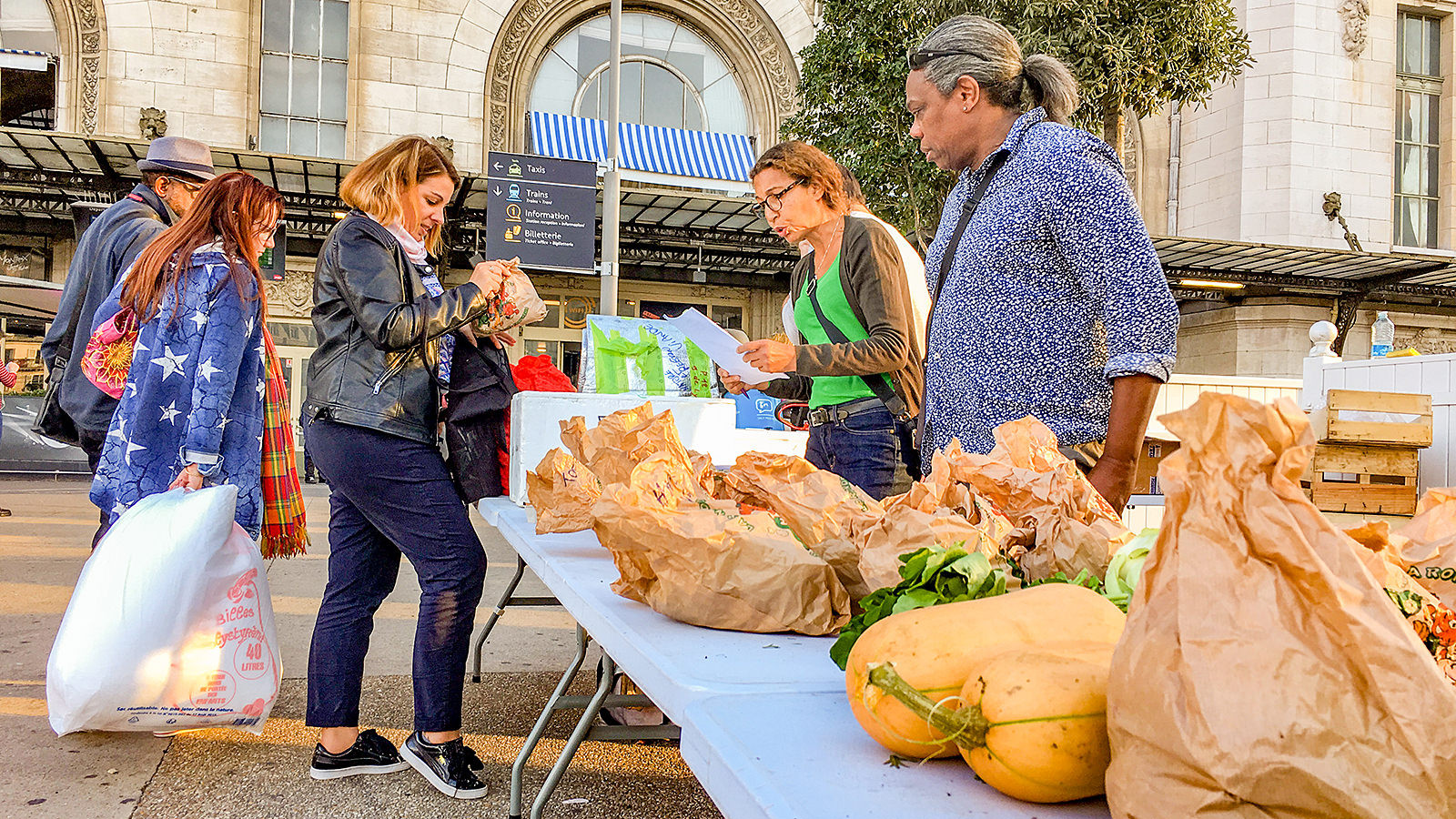 En handlende er ved at købe mad på et madmarked i Paris.