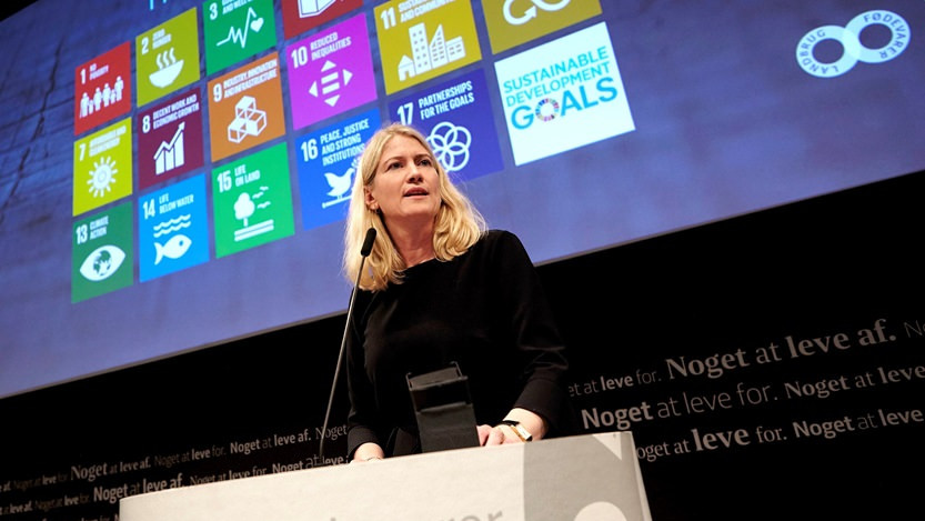 Anne Lawaetz Arhnung ses på en talerstol - bag hende viser skærmen FN's 17 verdensmål.