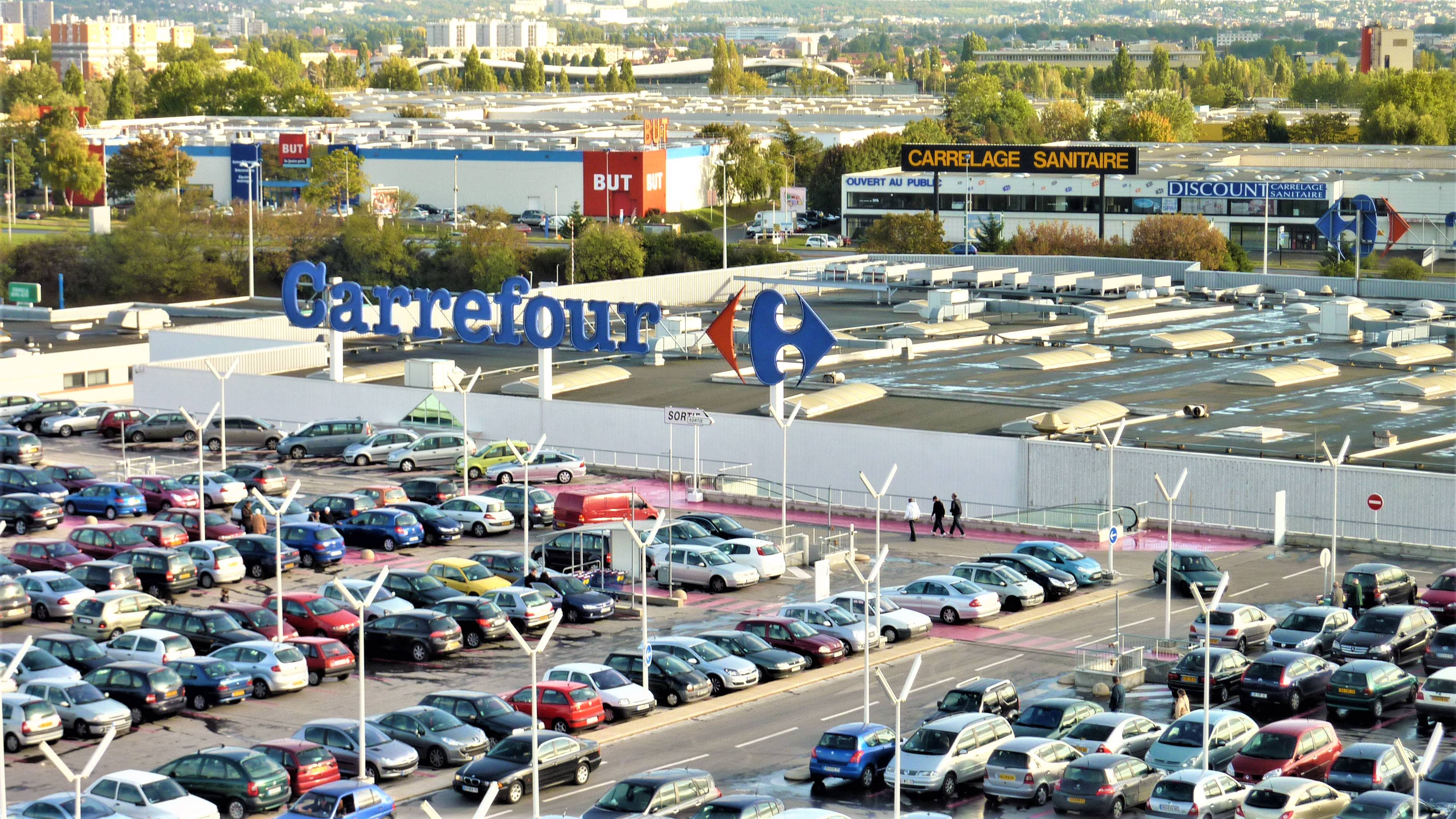 Et overbliksbillede viser en parkeringsplan på taget af en Carrefour-bygning