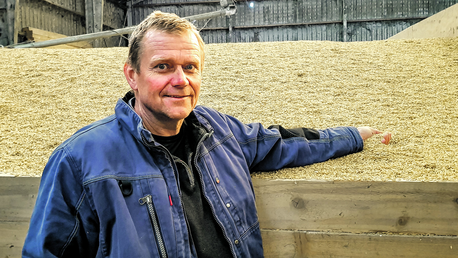 Bjarne Larsen står foran en bunke korn