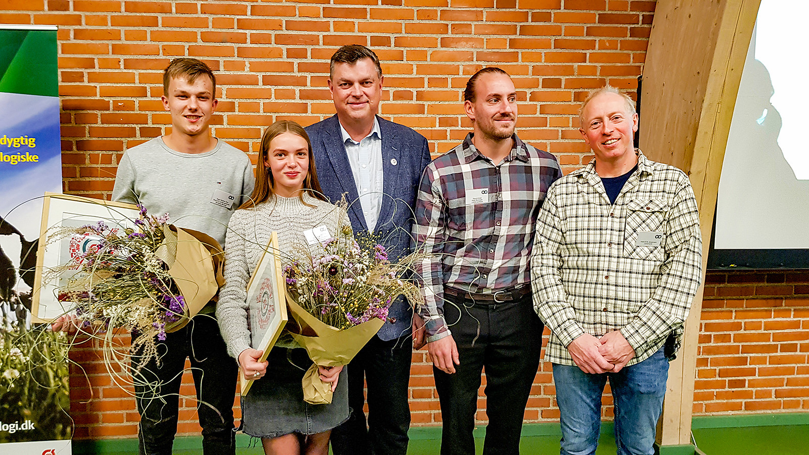 Vinderne af 'Årets øko-elev' står med blomster sammen med formanden for Økologisektionen og fødevareminister Mogens JensenFra prisoverrækkelsen