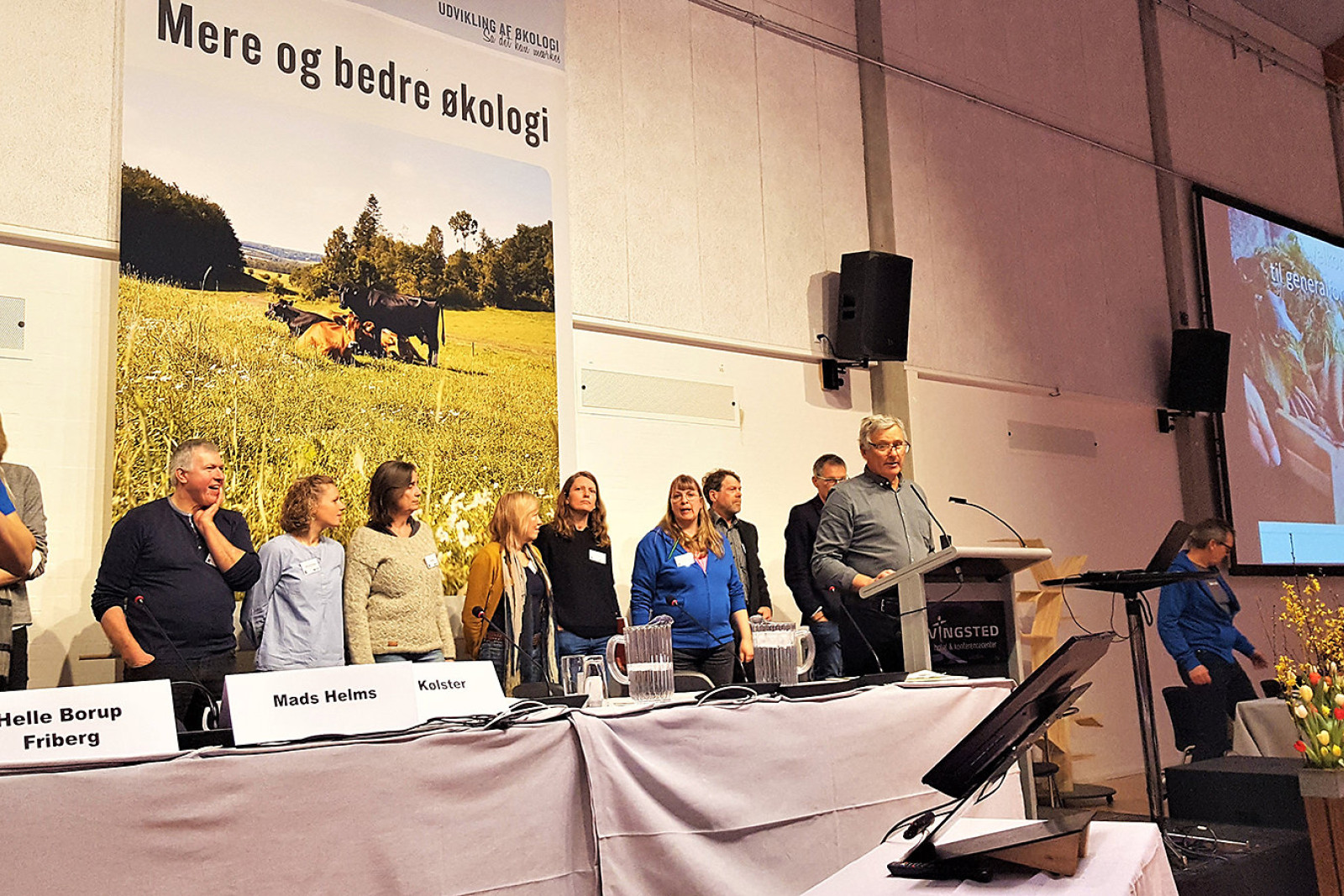 Bestyrelsesmedlemmer i ØL står på en række - foran dem står formand Per Kølster på talerstolen