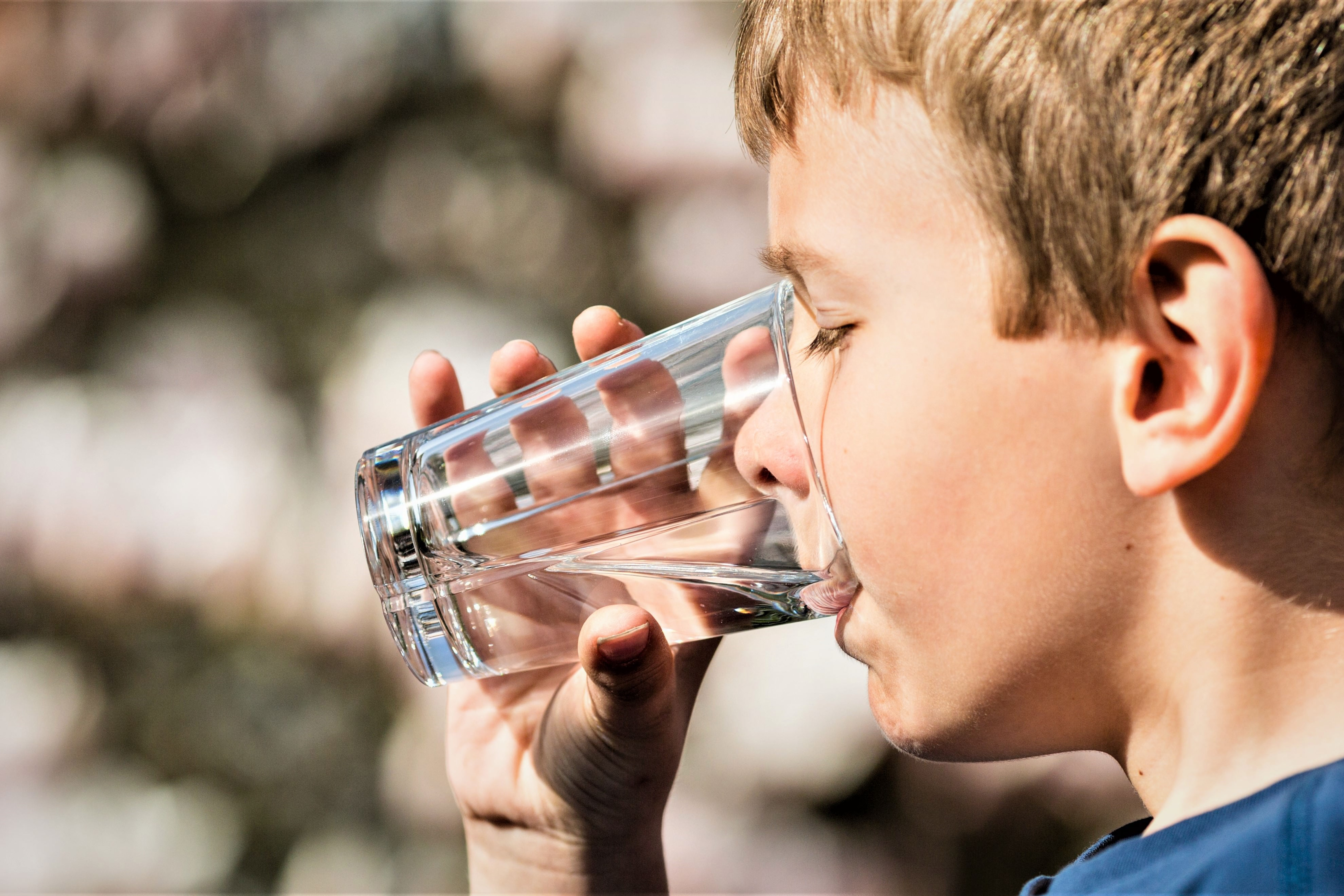 En dreng drikker vand af et glas
