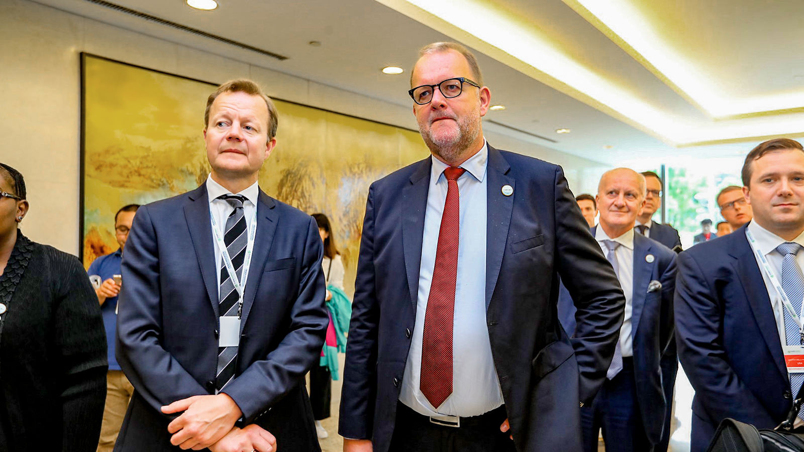 Klimaminister Lars Chr. Lilleholt ses omgivet af mænd i jakkesæt