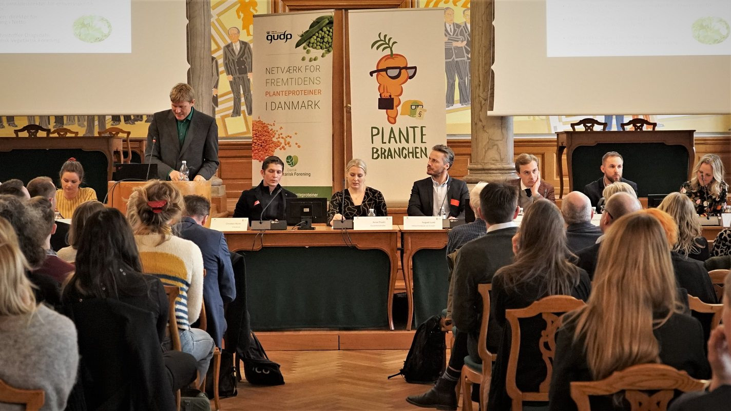 Konference om plantebaseret kosts bidrag til CO2-reduktioner i landbruget. Talspersoner sidder ved et langbord foran publikum