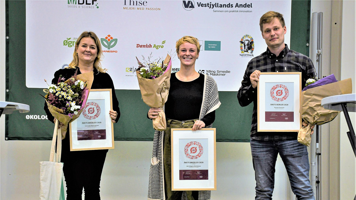Tre vindere står og fremviser diplom og blomster
