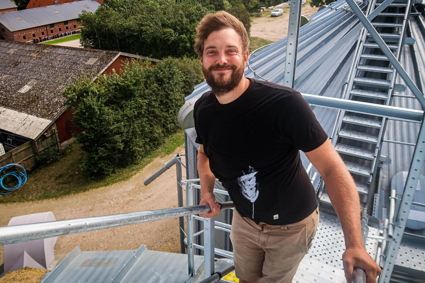 Andreas Poulsen står smilende på toppen af en silo